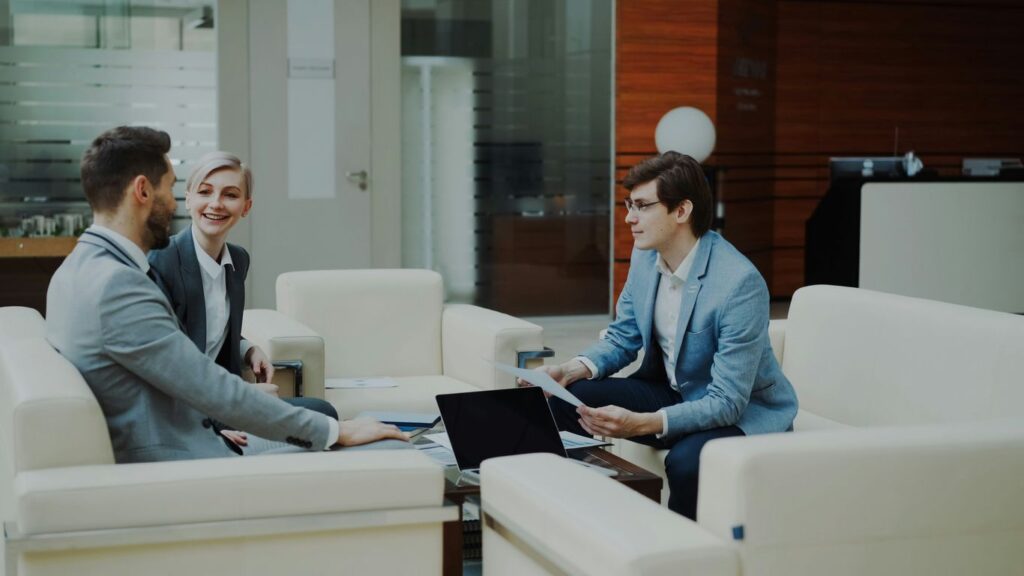Three professionals in a modern office lounge.