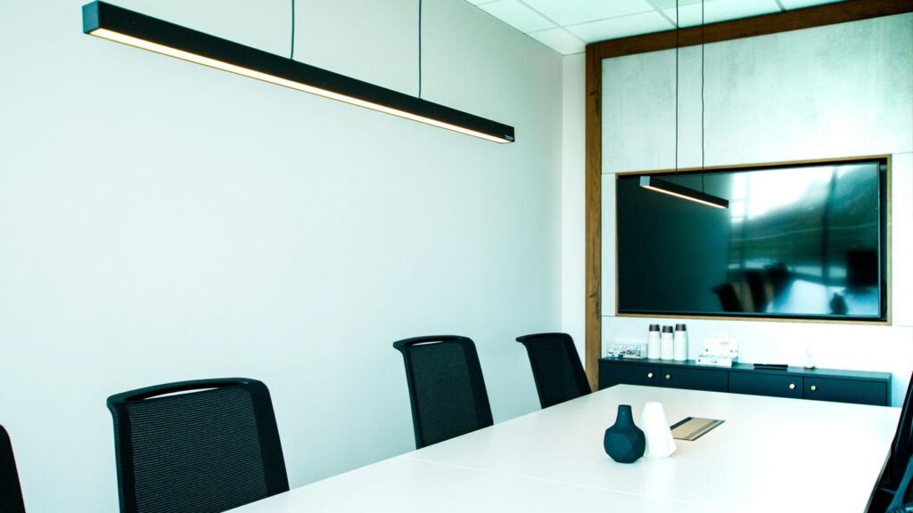 a conference room with a white table and black chairs